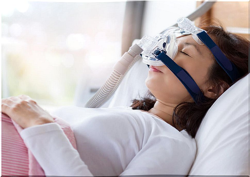 Sleeping woman with apnea mask to control snoring