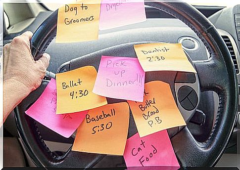 Person in the car with the steering wheel full of notes written with things to do