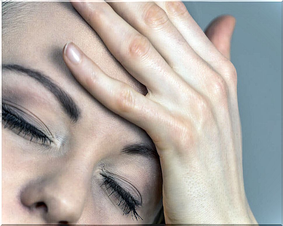 woman with hand on face for headache.